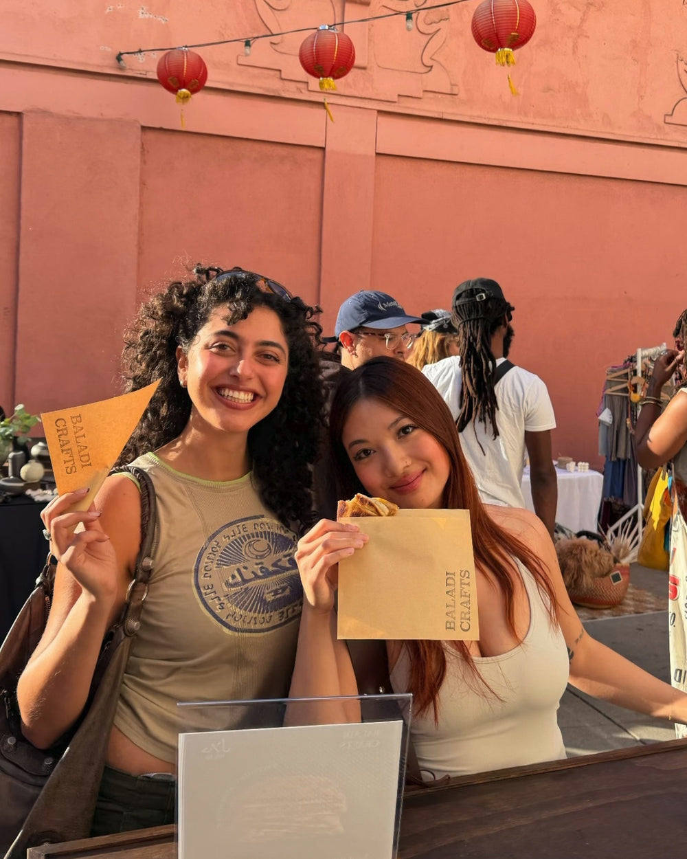 Baladi Crafts community customers holding branded packaging at a market